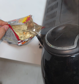 Hot water being poured into a ramyun bag for bboggeul-i, the Korean army cooking method