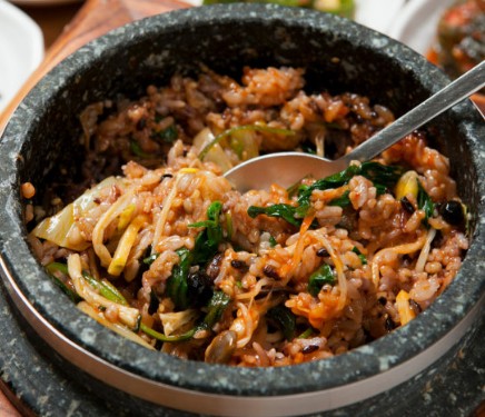 Bibimbap after being mixed together with a spoon, everything folded into one savory bowl