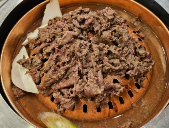 Grilled bulgogi — thin-sliced marinated Korean beef with caramelized edges on a hot pan