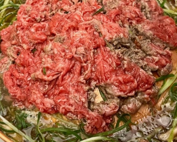 Thin-sliced beef soaking in bulgogi marinade — soy sauce, garlic, sesame oil, and grated Asian pear