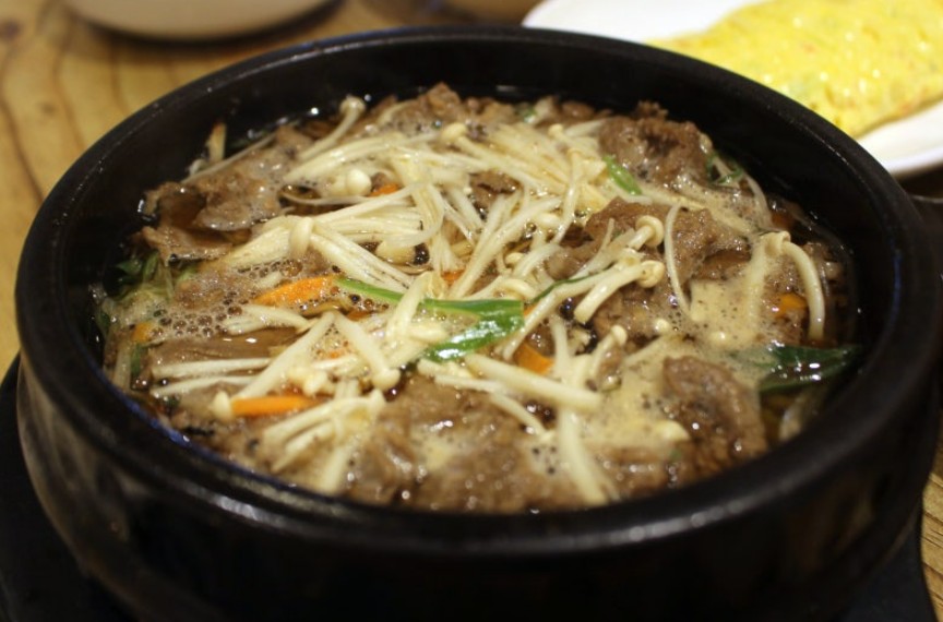 Bulgogi served in a bubbling ttukbaegi stone pot with sweet broth