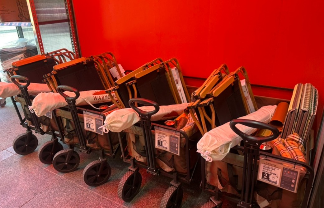 Folding wagons loaded with picnic mats and gear at a Han River rental stall