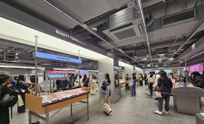 Wide view of Olive Young beauty tools and shoppers browsing a large store.