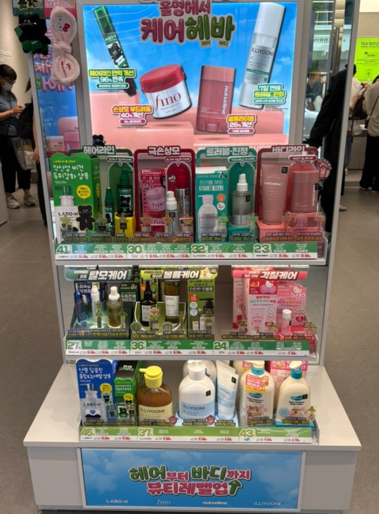 Promotional display with assorted cosmetic brands and offer labels.
