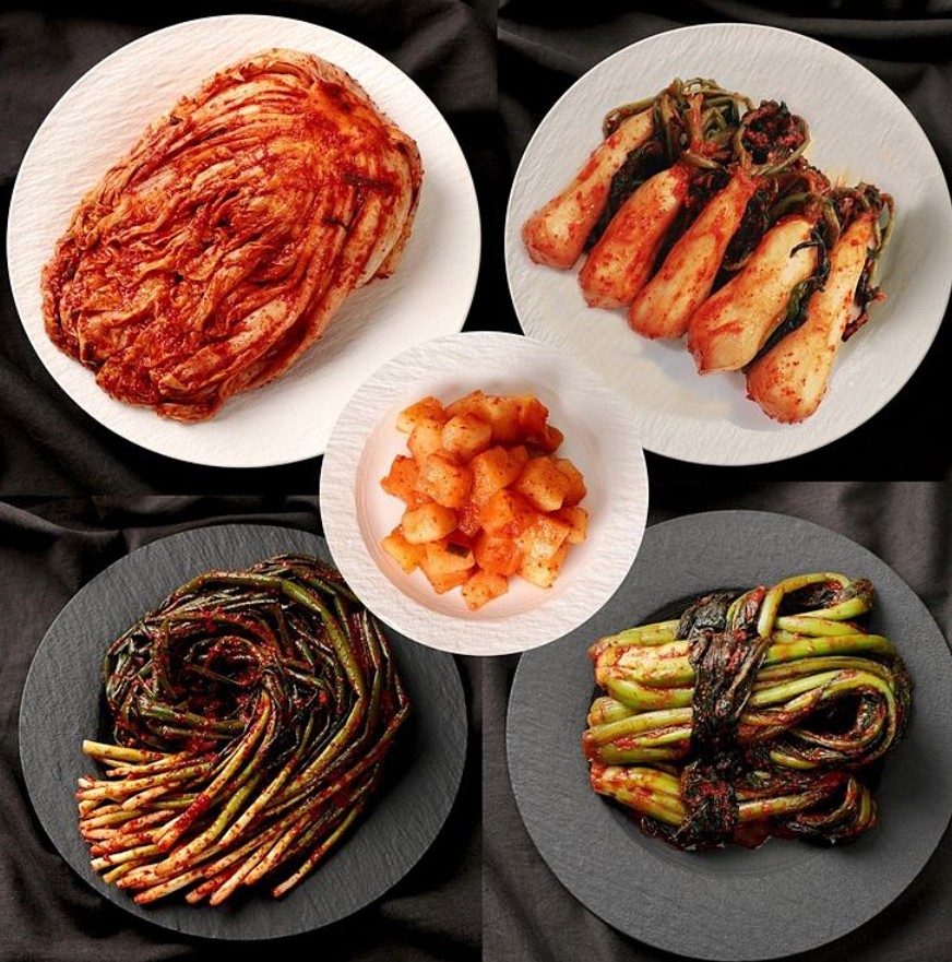 A spread of Korean kimchi varieties on a table — baechu, kkakdugi, pa, and more
