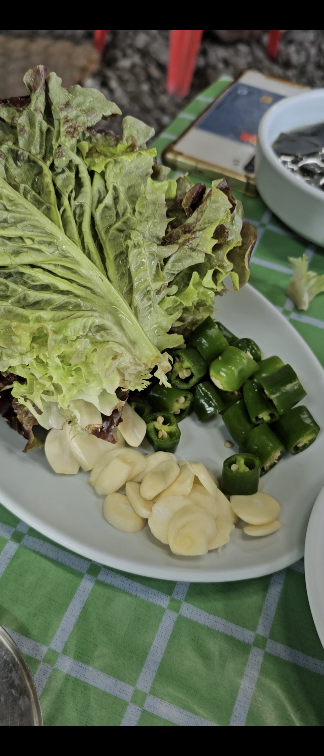 Lettuce, raw garlic, and green chili for making ssam wraps at Korean BBQ