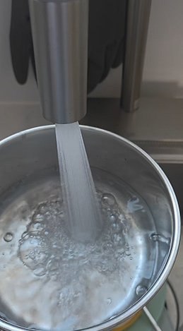 Filling a small pot with water from the tap