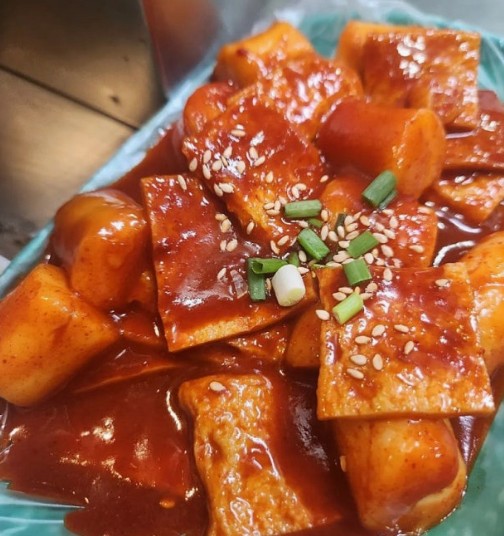 Classic tteokbokki — chewy white rice cakes simmering in a glossy red gochujang sauce